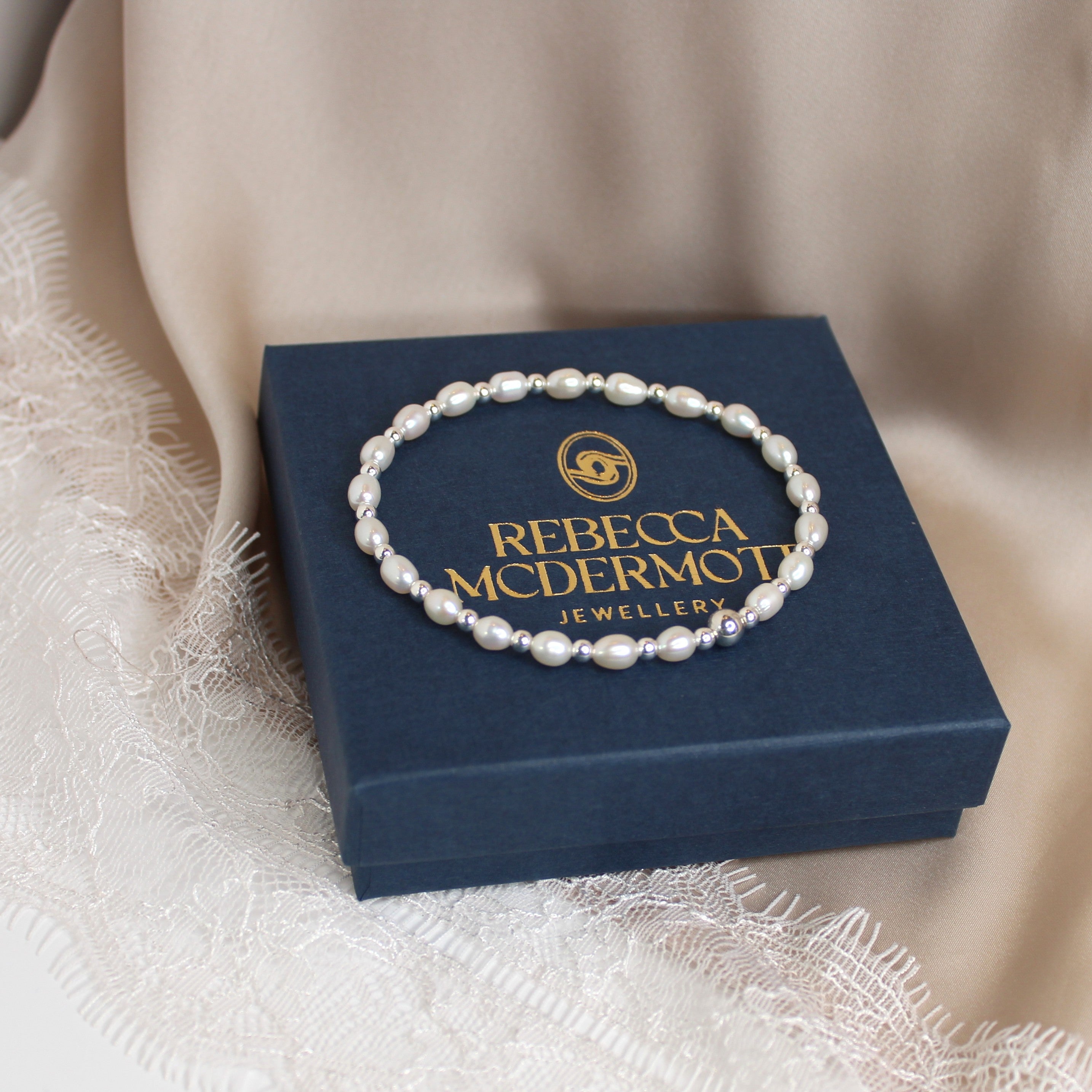 Pearl bracelet on a Rebecca McDermott jewelry box with a soft beige background